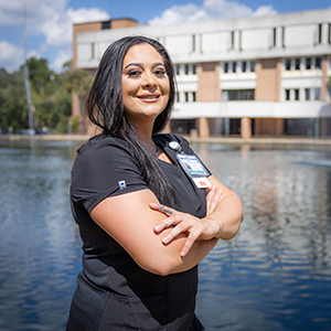 A photo of FDTC student Jenniffer Smirba standing by a fountain in front of the 5000 building at FDTC.