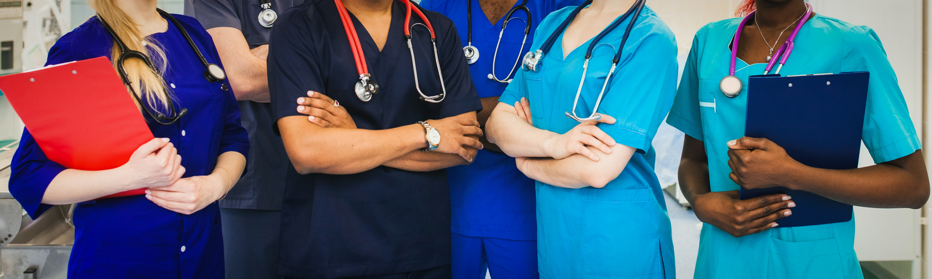 A group of nurses stand with arms crossed.