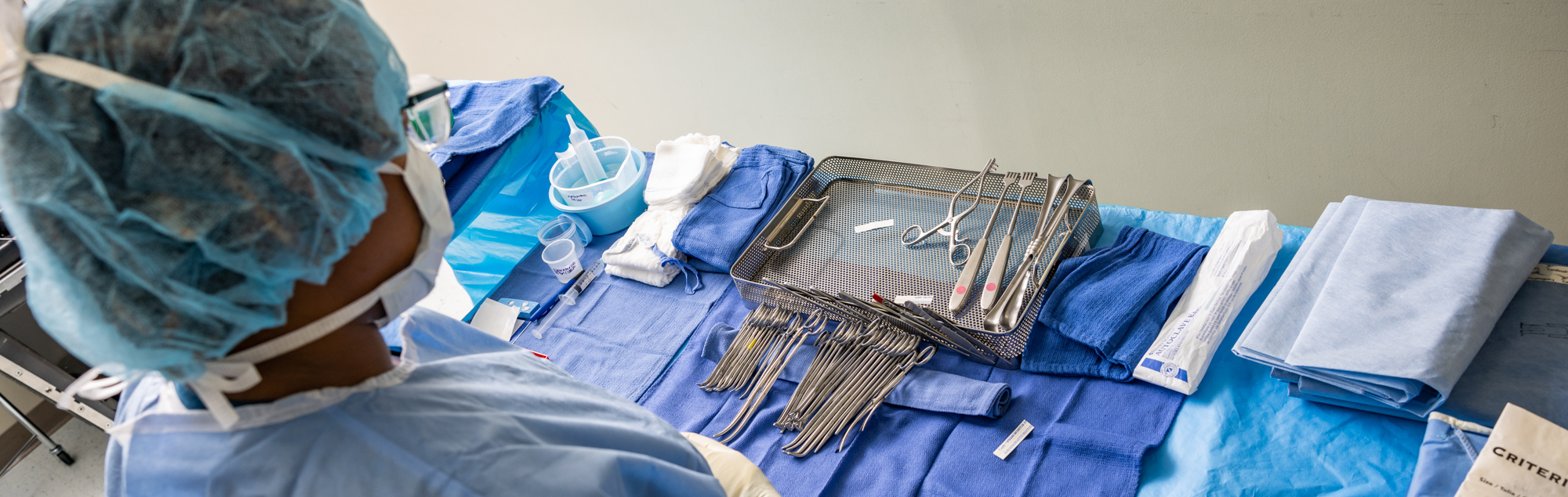 A surgical assistant student examines surgical tools