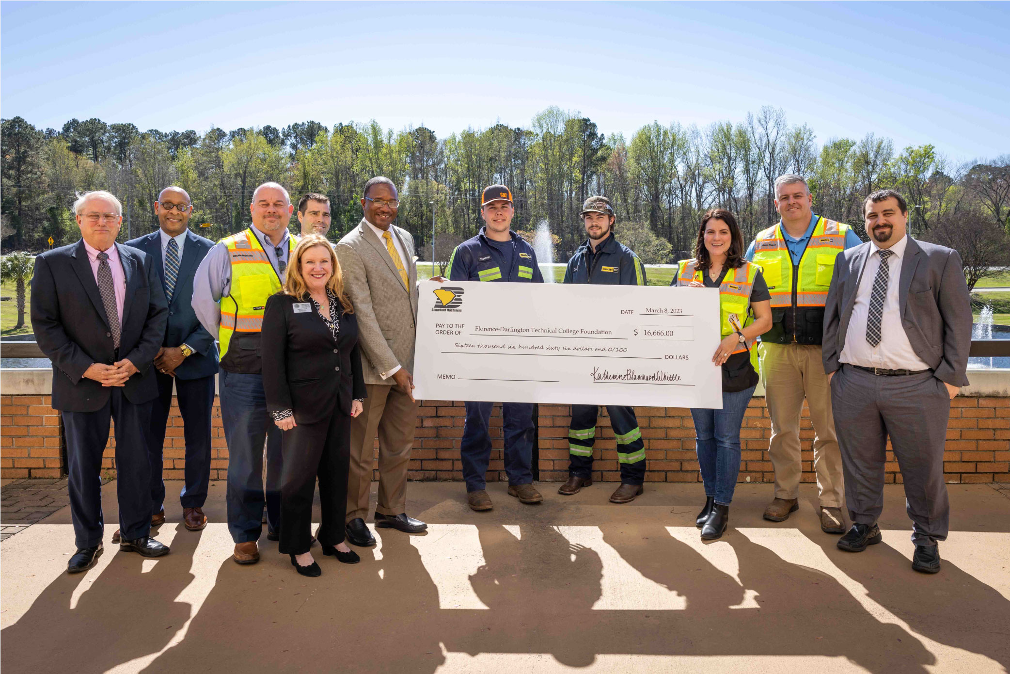 FDTC staff poses with CAT Blanchard staff for a photo with a large donation check.