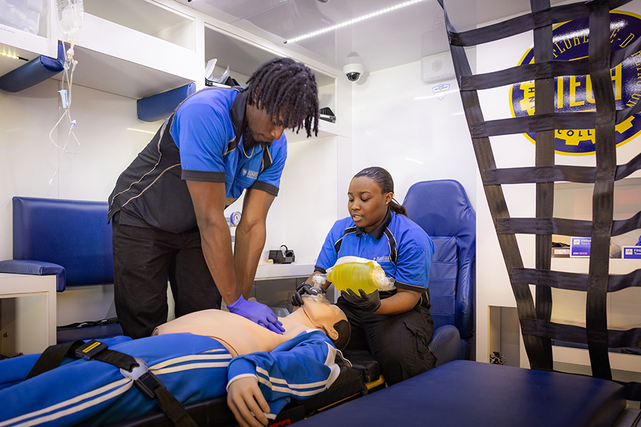 Two EMT Students are doing a training exercise in Florence-Darlington Technical College's Ambulance Simulator. They are performing CPR on simulator dummy.