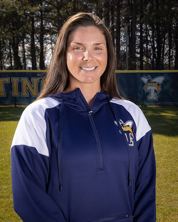 Coach Madison Ragan stands on the softball field.