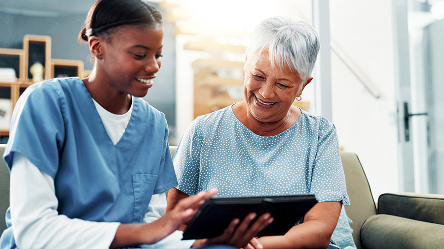 A medical assistant is helping a patient with a notebook computer.