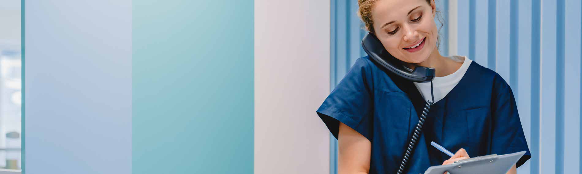 An Administrative Medical Assistant talking with a patient on the phone.