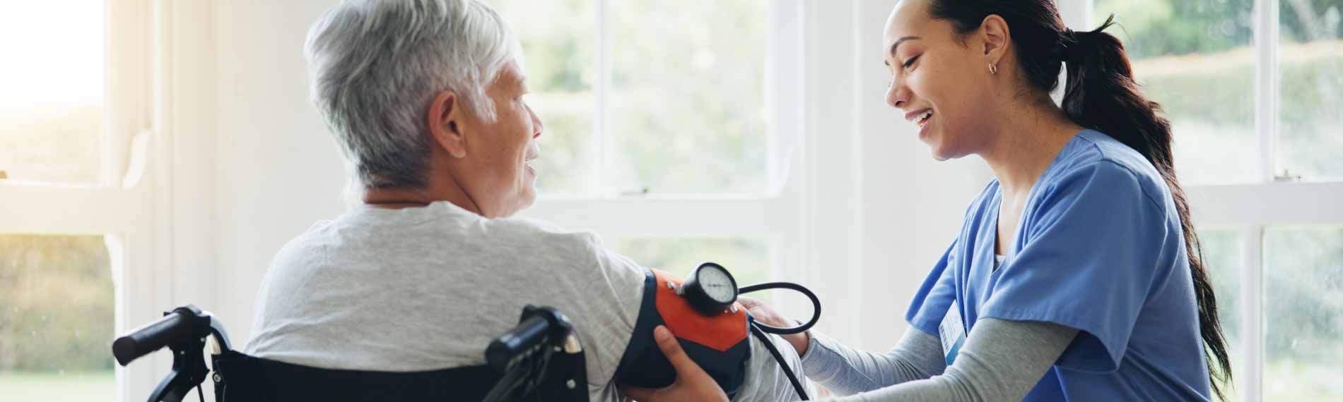 A Certified Nursing Assistant takes a patients blood pressure.