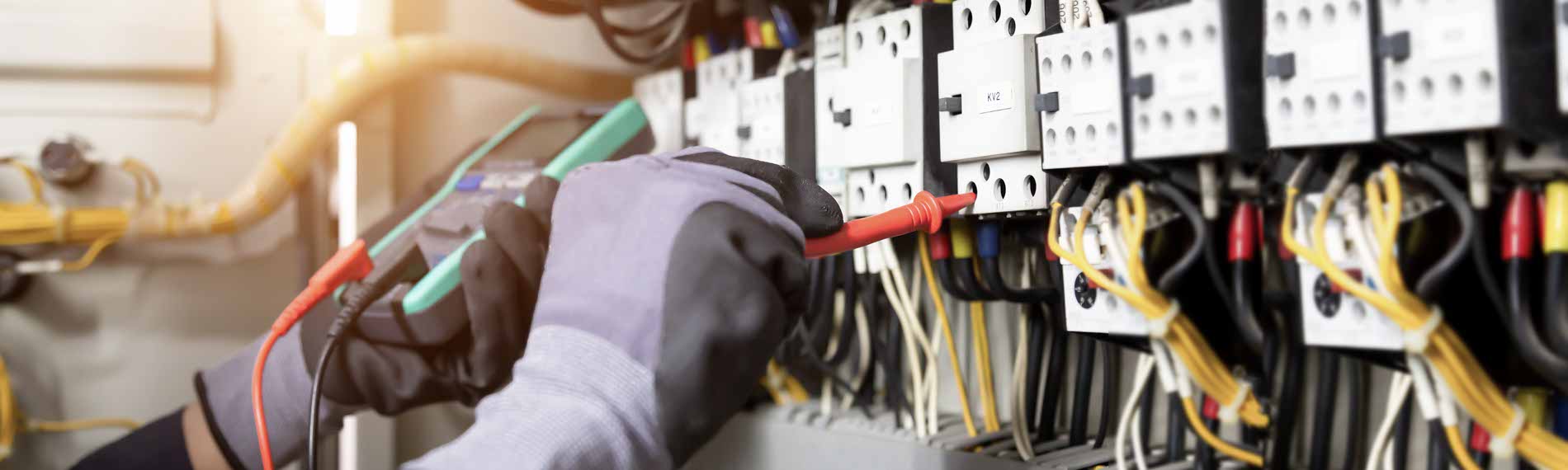 An electrician works on equipment.