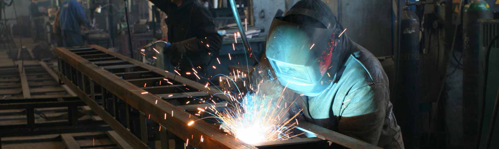 A welder working on a production assembly line.