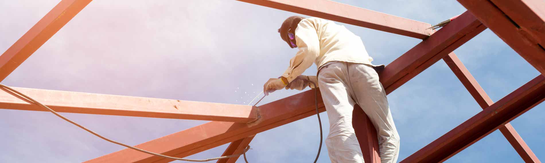 A Welder welding a steel frame of a building.